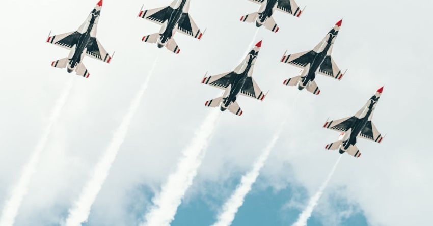 Flight Performance - From below of small airplanes flying in sky symmetrically and leaving contrail in air